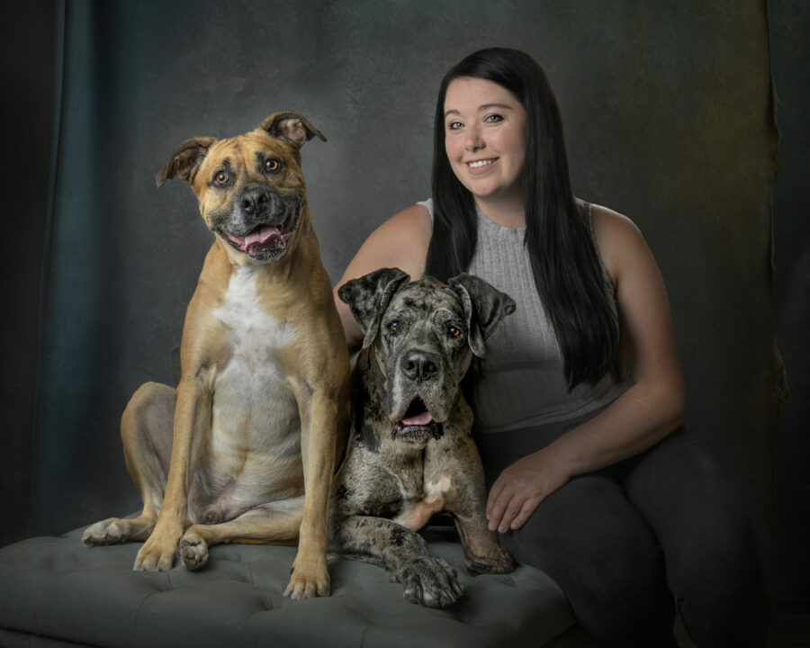 http://Woman%20with%20black%20long%20hair%20sitting%20with%20two%20dogs